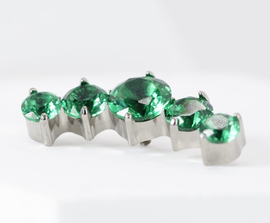 Labret de titanio con zirconias engastadas verde esmeralda para piercing